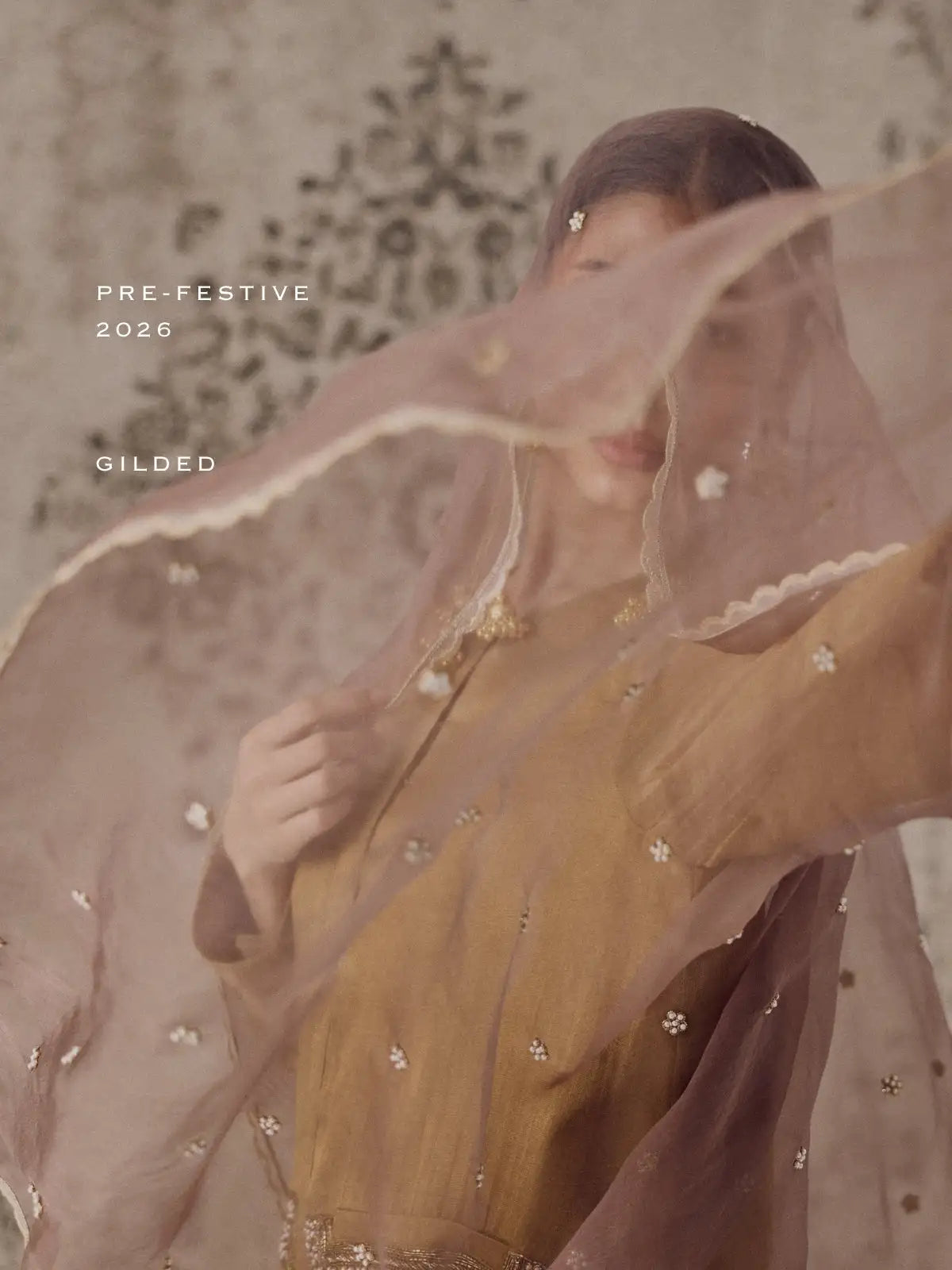 A delicate, sheer mauve veil adorned with tiny embroidered flowers and a scalloped edge.
