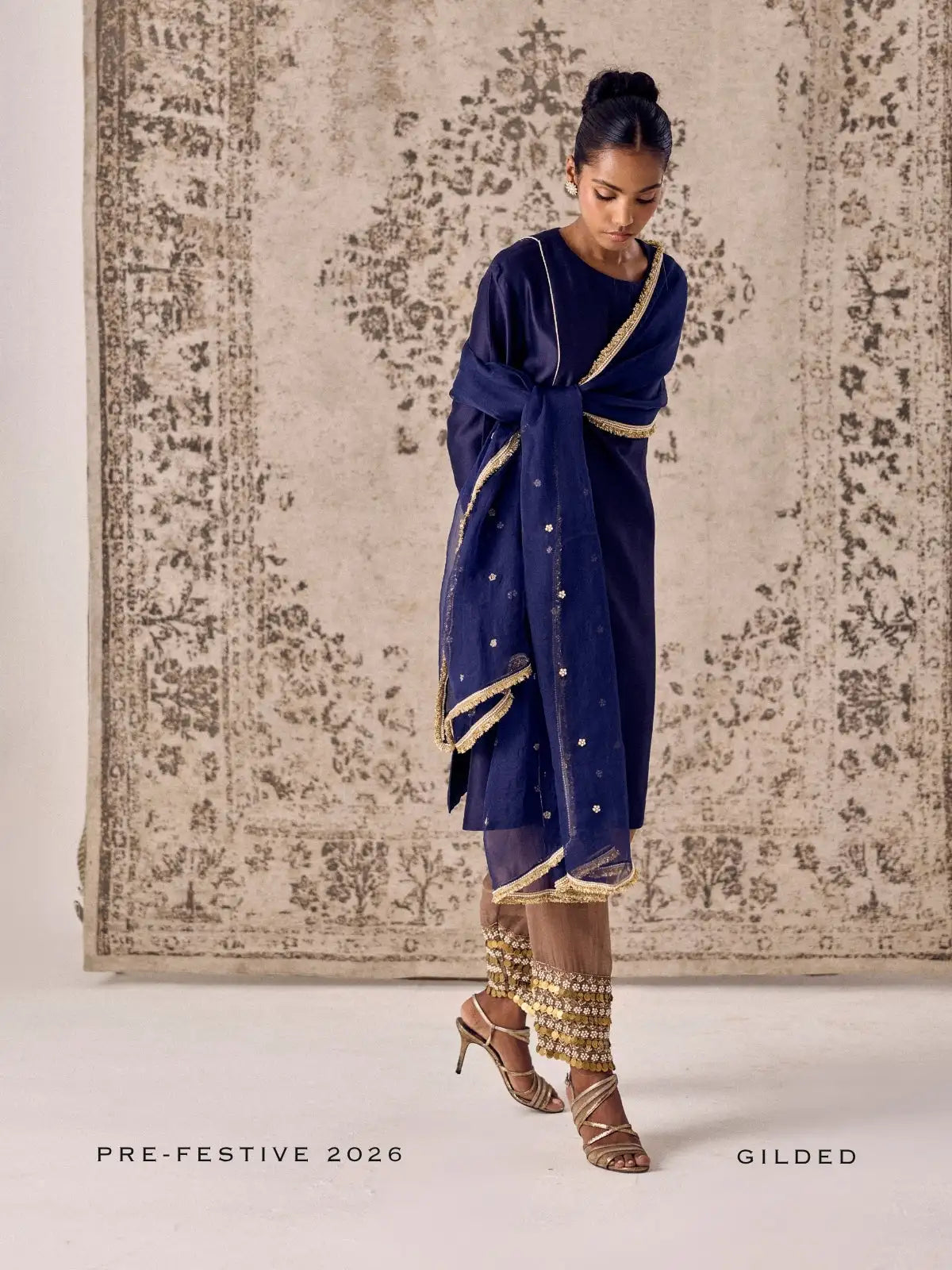 A navy blue embroidered dress with gold trim and subtle star embellishments, paired with matching golden-embellished leggings.