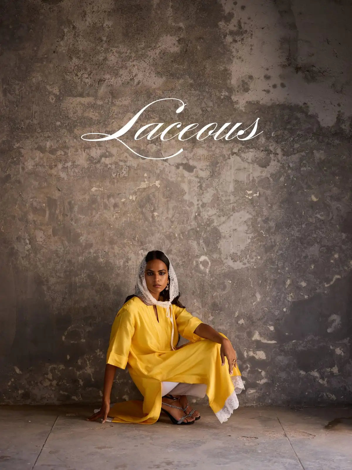 A woman wears a vibrant yellow, loose-fitting tunic with white lace trim along the sleeves and hem.